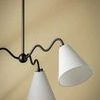 Side view showing two white linen shades and squiggly metal arms against beige background