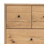 Close-up of drawer fronts with black metal knobs and dark resin wood cracks