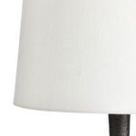 Close-up of white fabric drum shade's lower edge and lamp base transition