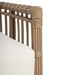 Close-up of upper armrest edge where rattan strands are looped and secured