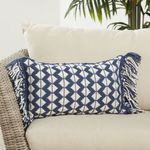 lumbar pillow styled on cream outdoor sofa with green plant background
