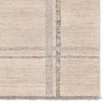 Detailed view of intersecting striped pattern and short gray fringe on rug edge