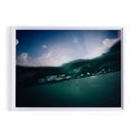 48x36 inch framed photograph showing underwater waveline with sun rays and cloudy sky above