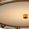 Detail of milk glass panels framed by warm antique brass metal ribs in geometric shapes