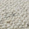 Close-up of ivory pillow showing chunky wool and cotton woven texture with subtle color variations