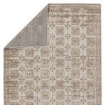 Top-right corner turned over revealing rug backing with same trellis pattern in muted tones