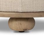 Close-up of round oak bun foot supporting the Bilbury Ottoman with visible wood grain texture