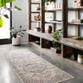 Teagan rug in runner size shown in hallway with rustic wood shelving and plants