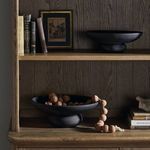 Two Perla Bowls styled on wood shelves with books and decorative beads in room context