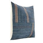 Angled shot of blue patchwork pillow highlighting block pattern and stitch details