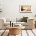 Living room with painting centered above sofa, wooden coffee table, and green plant