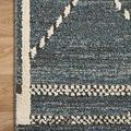 Top corner close-up of rug on wooden floor emphasizing border and geometric pattern