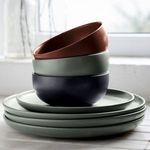 Stack of artichoke dinner plates with three nested matte-finish bowls in rust, artichoke, and dark gray