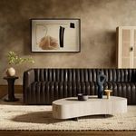Sofa displayed in rustic, warm-toned room with abstract framed wall art and coffee table