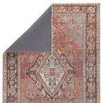 Back side of rug revealing solid gray woven backing and folded corner