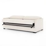Sofa bed halfway unfolded with mattress partially extended and pillows on backrest