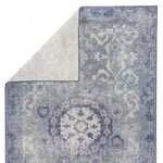 Rug partially flipped to reveal light beige underside contrasting the patterned blue-gray top.