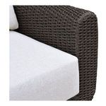 Close-up of armrest showing dark brown wicker weave and light gray cushion fabric