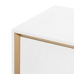 Close-up on top corner showing textured white lacquered linen surface and gold metallic trim detail