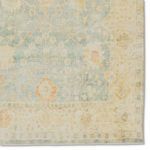 Close-up of corner detail highlighting subtle floral motifs and distressed pastel colors on Lovato rug border