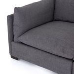 Corner seat close-up showing deep cushioning and charcoal upholstery weave texture