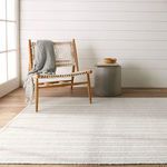 Rug in indoor living space with natural light, paired with wooden chair and cylindrical side table