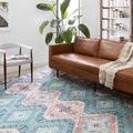 Skye Turquoise Terracotta Rug in living room with brown leather sofa, white chair, and plant