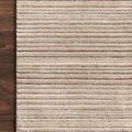 Close-up of Bellamy Oatmeal Rug corner styled on dark hardwood floor emphasizing texture and color variation