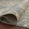 Edge of rug curled up to show low pile height, binding, and backing detail on wood floor