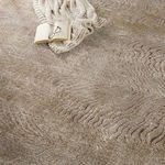 Close-up of Dune rug surface with knitted throw, open book, and reading glasses detailing texture