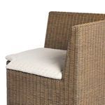 Close-up of tufted beige seat cushion fabric texture on woven bench