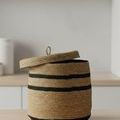 Bamboo box with lid open showing interior, placed on wooden surface in room setting