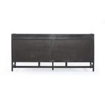 Sideboard leg and stretcher base with black-washed finish, showing foot leveler detail
