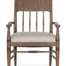 Front view highlighting the carved spindle back, rounded armrests, and upholstered beige seat of Americana arm chair