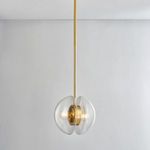Pendant lit with warm light, hanging centered against white wall and ceiling