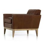 Side view of Roberts Sienna chair showing smooth leather back panel and light stained wooden legs.