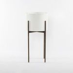 Close-up front view of the white pot and dark metal stand with visible frame structure and texture