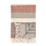 Same throw folded back at corner showing reverse side with similar striped pattern in muted red and gray