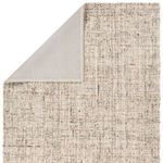 Top view of rug corner flipped to reveal smooth cream backing