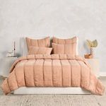 Front view of quilt set on bed with matching quilted pillows and neutral bedside tables