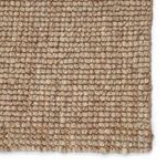 Close-up of tightly woven blend of jute and wool yarn in light gray and tan hues