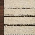 Section of Roman Natural Charcoal Rug on dark wood floor highlighting the woven texture and stitching detail