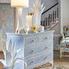 Hopper Lamp illuminated on blue patterned chest with decor in a living room setting
