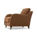 Brown fabric Lynne Chair angled side view highlighting rolled arm curves and profile