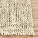 Side corner view highlighting rug’s edge and chunky textured weave on light wood floor