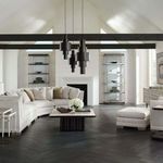 Living room setting with large curved Deep Retreat sectional sofa and matching ottoman on dark flooring under vaulted ceiling