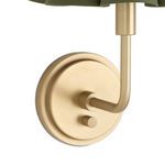 Close-up of natural brass base, curved arm, and round backplate with switch