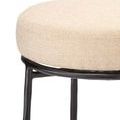 Close-up of beige textured fabric seat and iron frame of Asteria Iron Stool