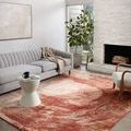 Spirit Rose Spice rug styled in modern living room with gray sofa, armchair, and white stone fireplace