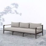 Sherwood outdoor sofa in gray fabric on stone tile floor with outdoor shadow and white wall background